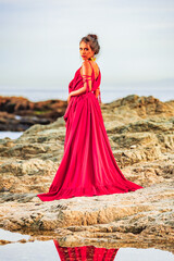Obraz premium woman photoshoot in a long red dress on the beach