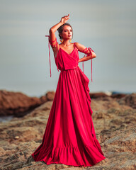 woman photoshoot in a long red dress on the beach