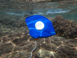 A blue medical mask to protect against corona virus was thrown into the sea, sea and ocean pollution, undersea pollution with waste, plastic, plastic bag and plastic bottle