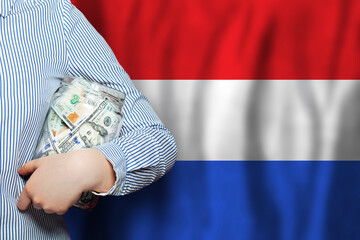 Netherlands politics, business and social problems concept. American dollars banknotes in hand on...