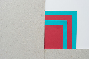 torn paper composition in turquoise blue, deep red, and mill board with space for text