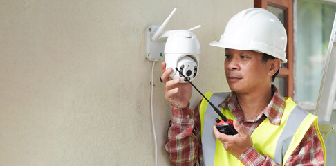 Professional technician installing CCTV cameras or surveillance systems in buildings, offices, intelligent cameras Can record video all day and night to keep you safe from theft, anti-theft system con