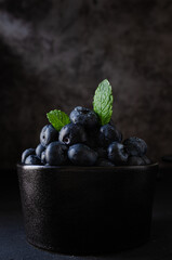 Blueberries in bowl dark background