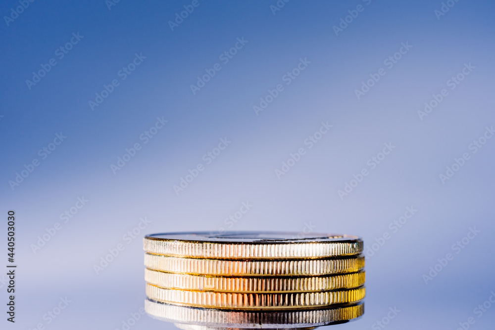 Wall mural several coins stacked in the center of the image with a bright blue background.