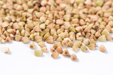 Pile of raw buckwheat isolated on white background.