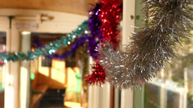 Christmas decorations hanging inside of moving empty classic train carriage.
