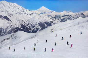 The view of skiers and Mount Damavand from Dizin ski resort in Tehran, Iran.