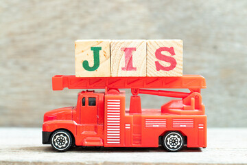 Fire ladder truck hold letter block in word JIS (abbreviation of Just in sequence) on wood...