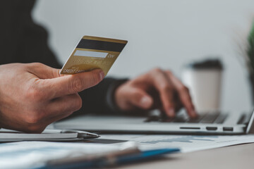 Close up of businessman hand using credit card and laptop computer for buying online shopping