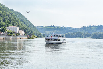 A boat drives on a river in Passau, bavaria