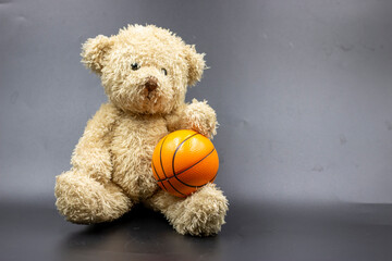 Teddy bear with basketball on black background