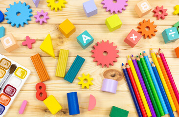 Colorful math fractions, cubes, pencils on wooden table. Interesting mathematics for kids....