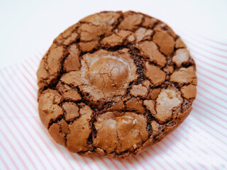 Cracked brownie cookie on white and pink striped paper