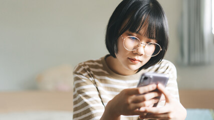 Young adult single woman using smartphone in the moring for online app mental health.