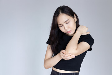 Obraz premium Asian woman suffering from tennis elbow syndrome or elbow joint pain, injury, rheumatoid or gout arthritis
