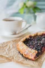 Pie or biscuit with blueberries and sesame seeds and a cup of aromatic coffee.