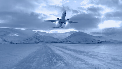 Fototapeta na wymiar Commercical white airplane fly up over take-off runway the (ice) snow-covered airport- Norway