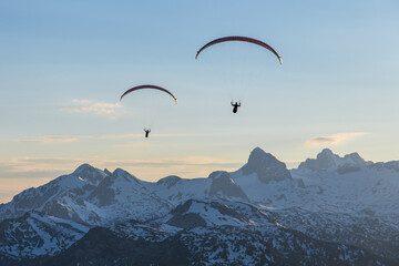 Paraglider duo flying over mountains