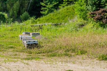 Several beehive boxes in grassy field in rural countryside.