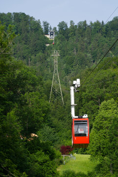 Red cable car at sunny summer day morning arriving at station. Photo taken June 18th, 2021, Zurich, Switzerland.