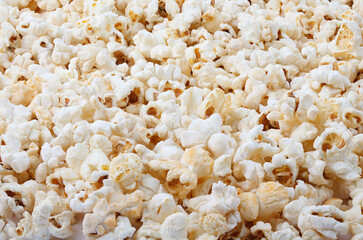 Heap of delicious popcorn, on white background. Scattered popcorn texture background. Full depth of field. Close-up.