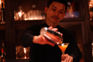 カクテルを注ぐバーテンダー