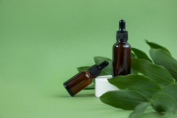 Amber glass cosmetic bottles, concrete podium on a green background. Natural organic beauty product...