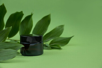 Cosmetic bottles from amber glass on a green background. Natural organic beauty product concept....