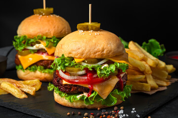 Burgers with beef patty close-up on a black background. Fast food.
