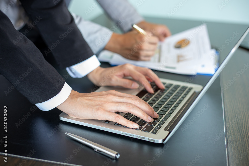 Poster close up asian businessman using laptop computer analysis documents and graph financial diagram on o