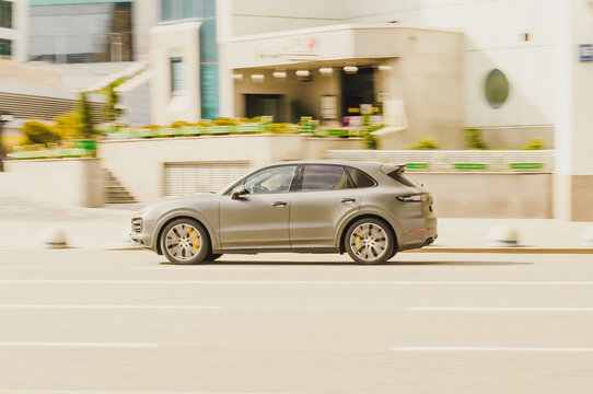 Grey Porsche Cayenne 9Y0 in motion. Speeding in city road concept