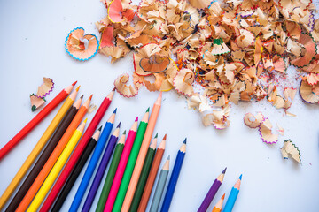 Sharpend crayons on a white background. Pencil shavings, different colors crayon pencil scrap. pencil peels. pencil sharpener