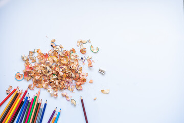Sharpend crayons on a white background. Pencil shavings, different colors crayon pencil scrap. pencil peels. pencil sharpener