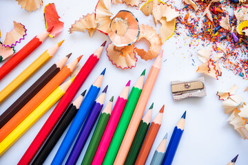 Sharpend crayons on a white background. Pencil shavings, different colors crayon pencil scrap. pencil peels. pencil sharpener