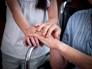 Little girl holding elderly woman patients hands in day hospital. Little girl helping elderly patients with Alzheimer's disease..