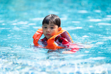 Fototapeta na wymiar Happy Asian family vacation. Young Asian father with son and daughter enjoy by swimming pool at the hotel. Happy family summer vacation concept.
