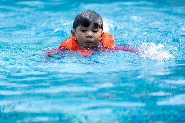 Happy Asian family vacation. Young Asian father with son and daughter enjoy by swimming pool at the...
