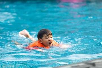 Happy Asian family vacation. Young Asian father with son and daughter enjoy by swimming pool at the hotel. Happy family summer vacation concept.