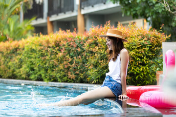 Fototapeta premium Young beautiful Asian woman relaxing in swimming pool at spa resort.