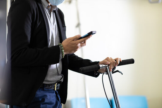 Asian business man passenger using smartphone and holding electric scooter eco urban transport. Ecological transportation concept