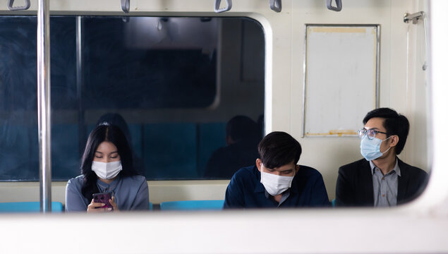 Crowd of passengers on Urban Public Transport Metro. Asian people go to work by public transport. Face Mask protection against virus. Covid-19, coronavirus pandemic