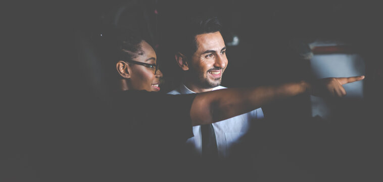 African American female worker and man customer choose and inspecting car part products while working in a old car part warehouse store.