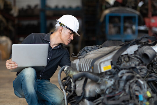 Mechanical Man Owner Small Business Inspecting Old Car Parts Stock On Laptop Computer While Working In Old Automobile Parts Large Warehouse