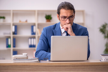 Young male employee sitting in the office