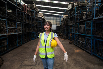 Fototapeta premium Portrait warehouse managers or worker asian woman working at large distribution warehouse of old car part.