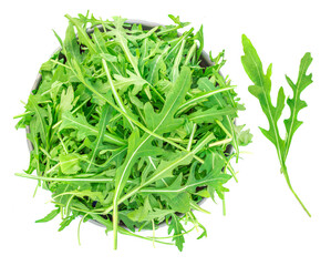 Rucola leaves in a bowl isolated on white background. Green fresh  Rocket salad or arugula leaf, top view.