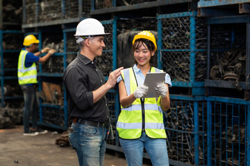 Warehouse managers and worker asian team working and discussing with desktop computer at large distribution warehouse.