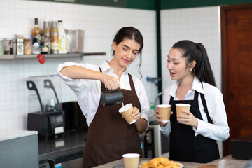 Nice stylish cheerful asian women barista making Coffee with coffee machine in the coffee shop