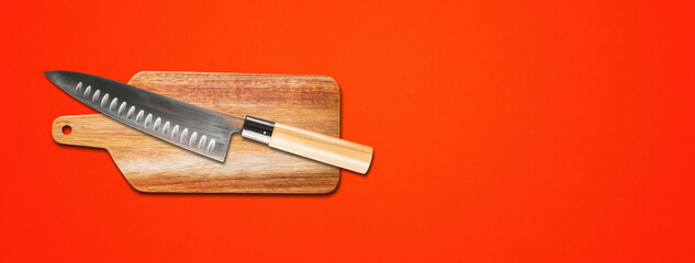 Traditional Japanese gyuto chief knife on a cutting board. Red banner background