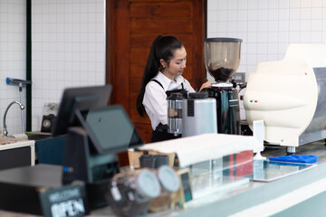 Nice stylish cheerful asian women barista making Coffee with coffee machine in the coffee shop